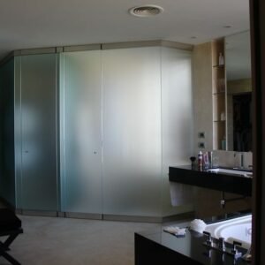 Mampara de vidrio templado con vinílico en un baño.